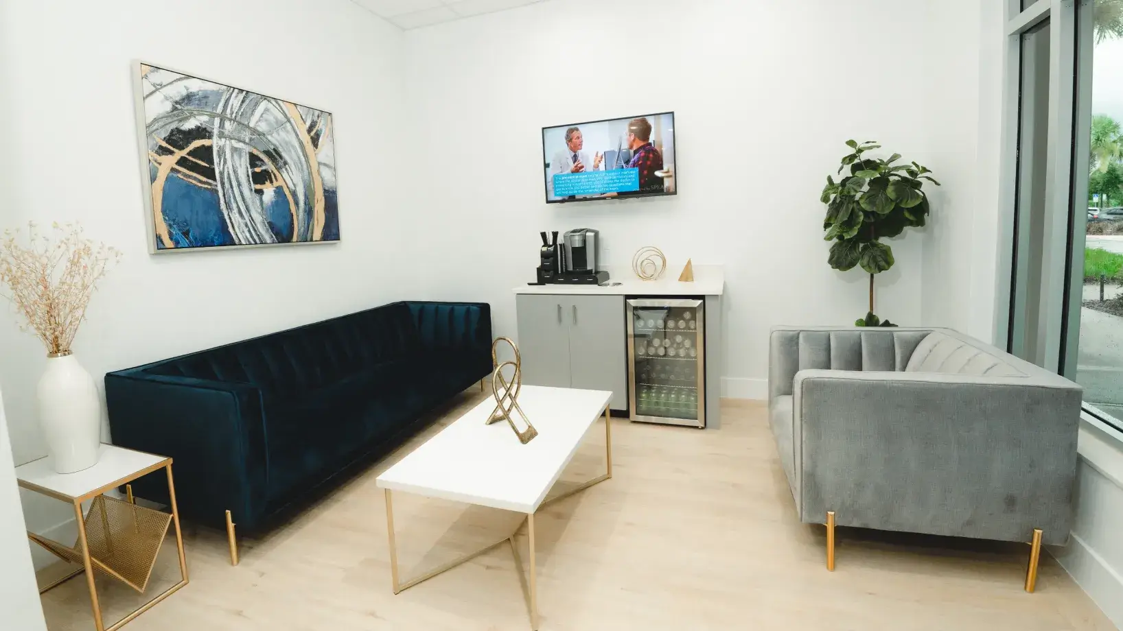 Comfortable waiting room with cozy couches, coffee bar, and modern decor at Charming Smiles of Ocoee